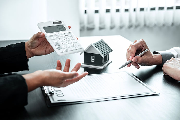 Buyer and agent negotiating over a contract with a calculator and a model house