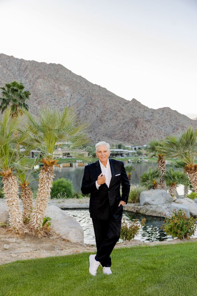 Steve James beside a lake and palms in Rancho Mirage